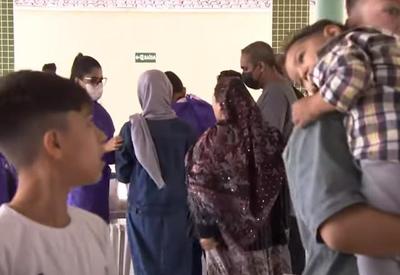 Refugiados afegãos recebem vacina e comida na chegada a abrigo em Praia Grande
