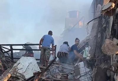 Após incêndio em supermercado, moradores buscam alimento entre entulhos